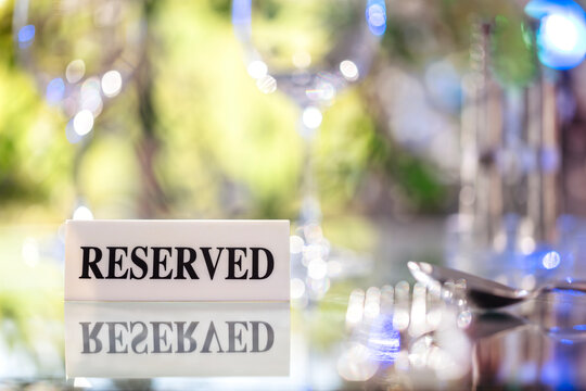 Restaurant reserved table sign with place setting and wine glasses ready for party