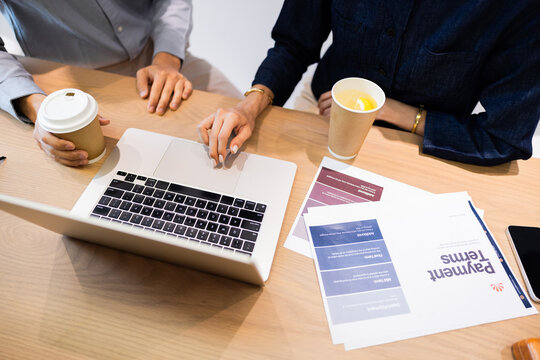 Meeting at a Table With Coffee and Laptop in a Shared Workspace
