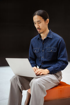 Man Works on Laptop in Modern Indoor Setting