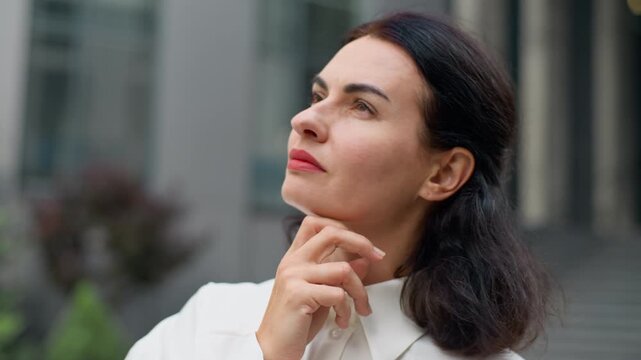 Close up pensive Caucasian middle-aged business woman thinking idea looking away in city thoughtful hesitate businesswoman think solution in downtown female worker serious pondering decision outdoors