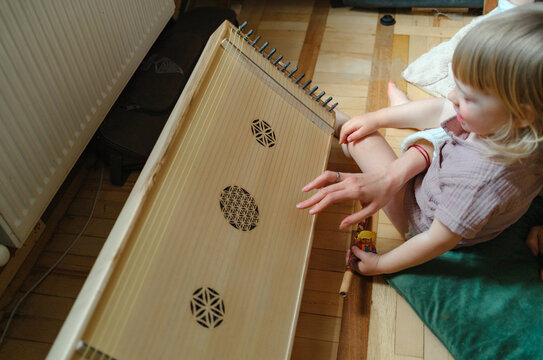 Close-up of a child learning to play a traditional stringed instrument