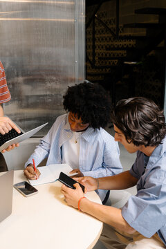 Hybrid work team collaborating at a table in a coworking space.