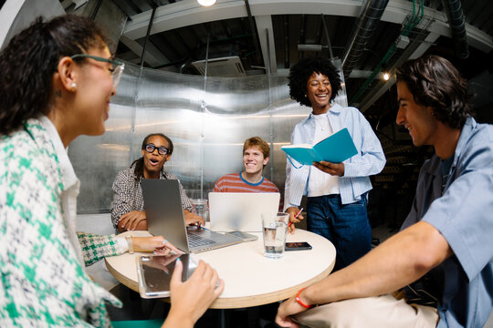 Wide shot of creative people working together in a coworking space.