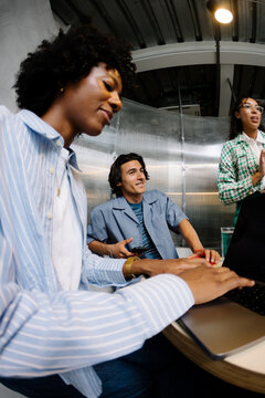 Professional creatives seated at a round table in a coworking space.