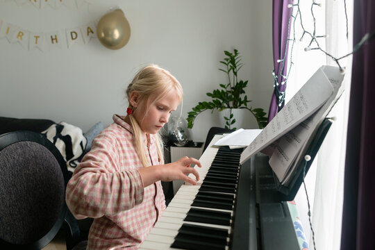 Preteen child is practicing the piano at home