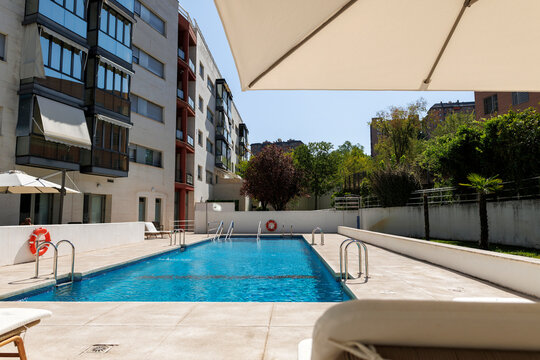 Swimming pool with sun loungers in residential complex