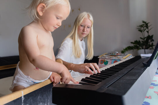 Teenage girl and her little sister play the piano