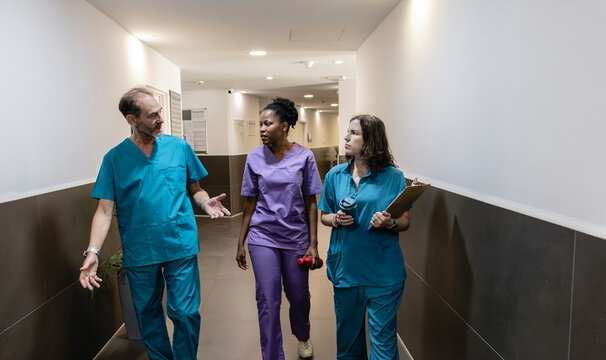Healthcare team walking through hospital hallway discussing