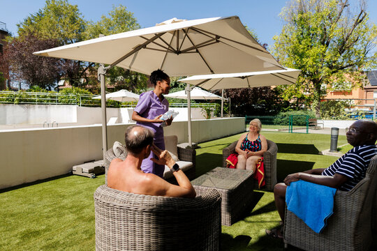 Caregiver assisting senior residents relaxing at retirement home