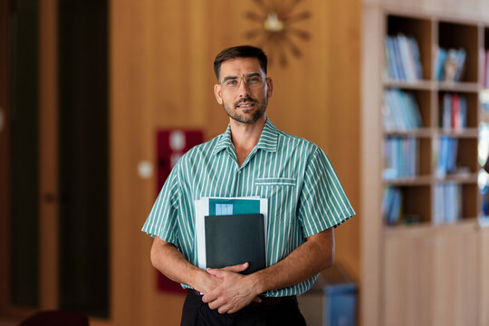 Young Professional Holding Folder in Office Library