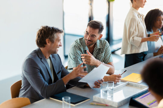 Business Team Discussing Documents During Casual Office Meeting