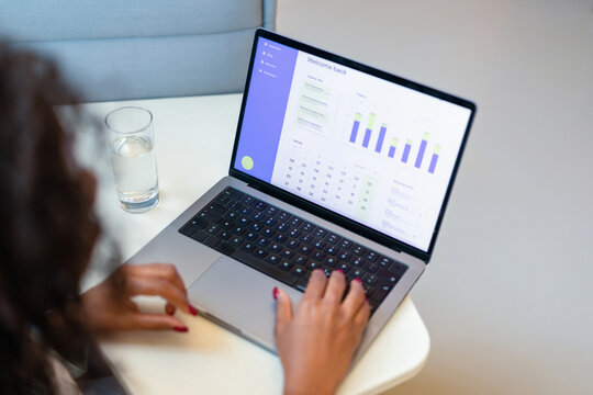 Woman Working On Laptop Viewing Business Analytics Dashboard