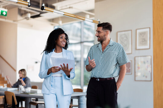 Smiling Colleagues Walking and Talking in Office
