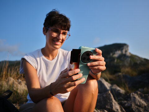 Woman capturing solar eclipse with smartphone and solar filter