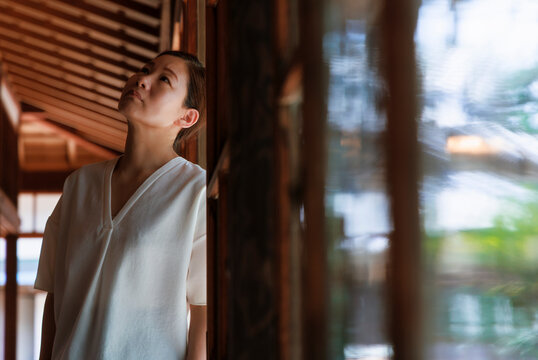 Slow Life Portrait under Japanese Eaves: Woman Leaning Lazily