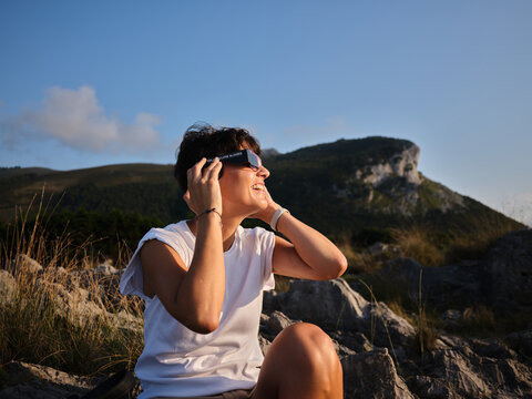 Woman observing solar eclipse with safety glasses in mountains