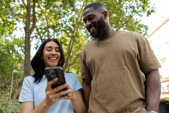 Diverse friends sharing humor while viewing smartphone content