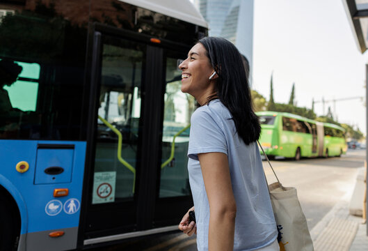 Young woman smiling while waiting for public bus