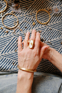 Woman's hand displaying jewelry rings and bracelet overhead