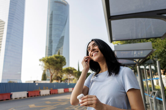 Young woman enjoying wireless audio in modern city