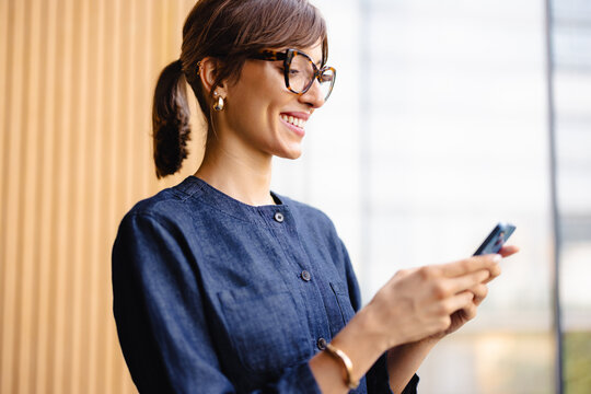 Woman Looking at Her Phone Inside a Building