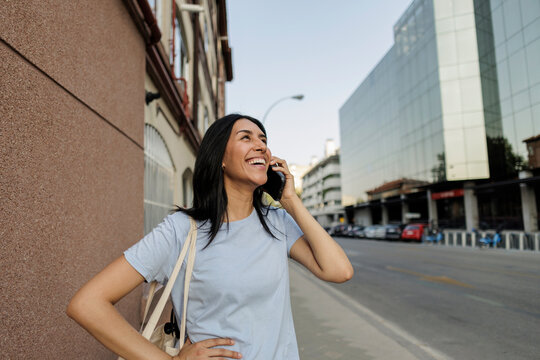 Happy woman talking on phone enjoying city life