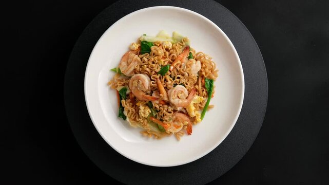Stir fried flat instant noodle with Shrimp and eggs in white plate.Top view.	