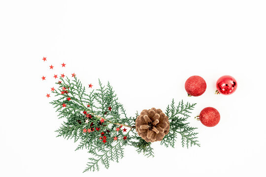 Christmas greenery with pinecones and berries arranged on white