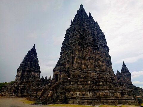 Majestic Prambanan Temple in Yogyakarta, Indonesia, showcasing intricate Hindu architecture, towering stone spires, ornate carvings, and a dramatic cloudy sky.