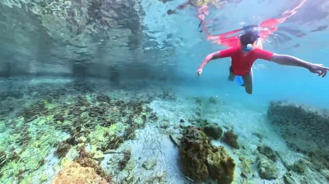 Underwater view of woman swimming in Pointe du Bout beach of Martinique, French Antilles in caribbean of France