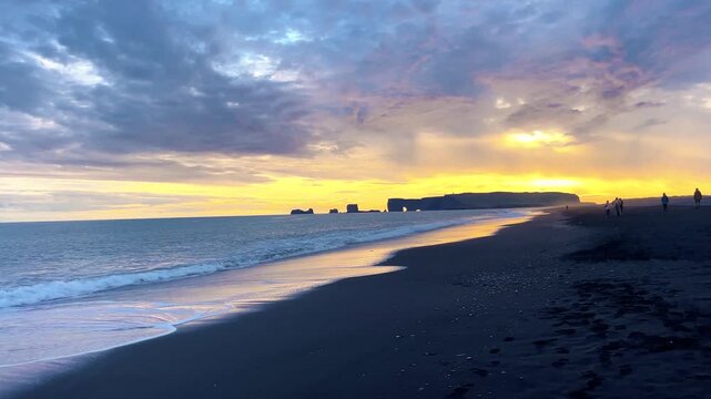 Dramatic Sunset Over Black Sand Beach and Ocean Waves in Iceland