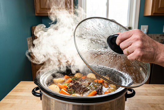 Slow Cooker Braised Beef Stew with Root Vegetables and Steam in a Home Kitchen