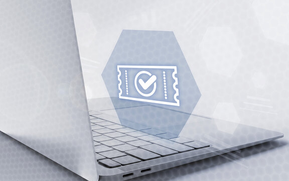 Ordenador port&aacute;til con icono hologr&aacute;fico de ticket confirmado y marca de verificaci&oacute;n para reservas online seguras, gesti&oacute;n de entradas digitales y comercio electr&oacute;nico corporativo.
