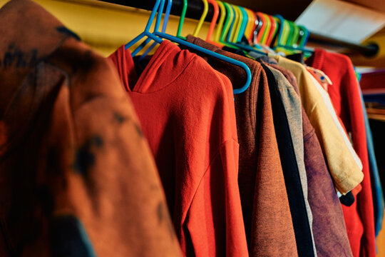 Clothes Hanging on Colorful Plastic Hangers on a Rack
