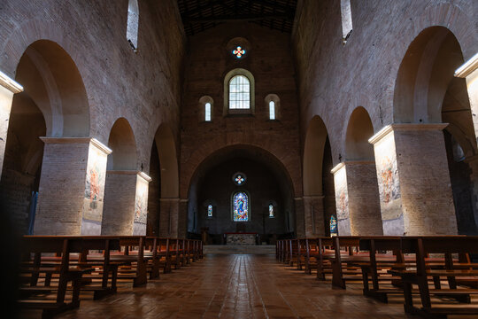 Interior view of central nave and altar of Church of Saints Vincent and Anastasius with wooden pews at Tre Fontane Abbey, Rome, Italy
