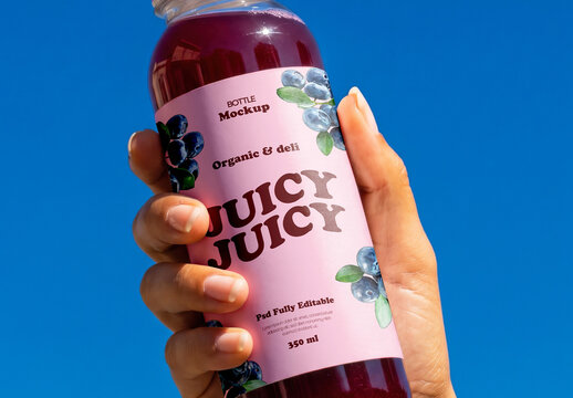 Hand Holding Juice Bottle Against Sky Mockup