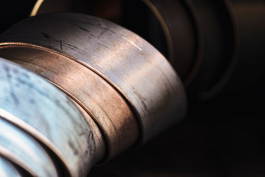 Closeup view of twisted flat steel strips and metal profiles, showing their surface texture, irregular contours and intersecting lines, torsional deformation and the structural characteristics of meta