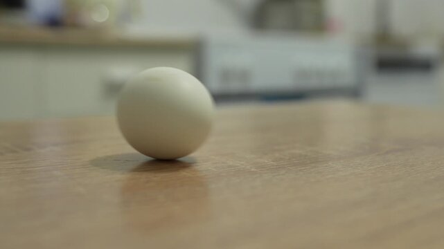 Boiled egg spinning on a kitchen table in a home kitchen, showing a simple breakfast preparation and everyday food routine