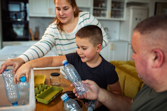 Family sorting plastic bottles for recycling at home