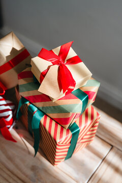 Collection of wrapped Christmas gifts with ribbons on a wooden table