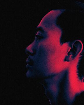 Asian man profile portrait with neon red and blue dual lighting effect