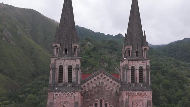 Basilica of Covadonga with Twin Bell Towers Surrounded by Green Mountains in Asturias, Spain