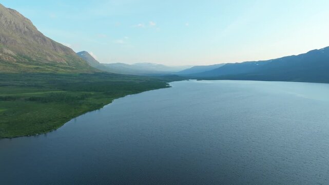 Aerial drone push in shot over the vast &Aacute;beskoj&aacute;vri lake, nestled within the stunning wilderness of Lapland, Sweden. This scenic landscape is part of the famous Kungsleden hiking trail.