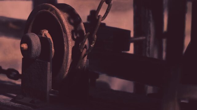 Rusty gears and chains of an old machine catch the glow of the evening light, revealing history and craftsmanship. This scene evokes curiosity about its past use and purpose.