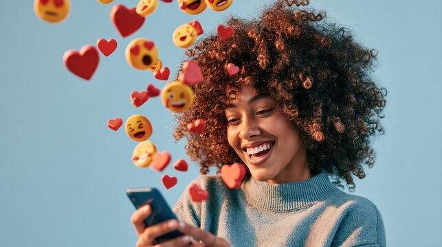 smiling young woman holding smartphone with floating red hearts and emoji reaction icons