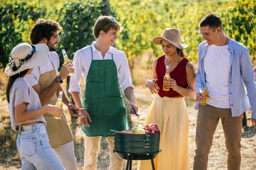 Naklejka premium Diverse friends preparing food and socializing together in a vineyard