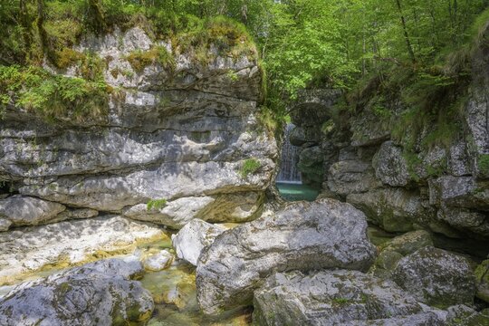 Cascata Rio Repepeit a small artificial waterfall with stone bridge, Chiusaforte, province of Udine, Italy