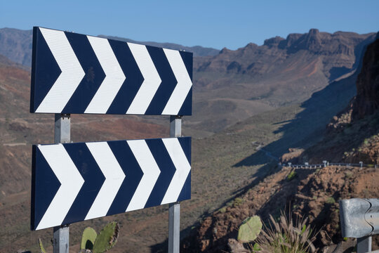 Sharp bend road sign in the rugged mountains near Mirador Degollada de la Yegua viewpoint on the Spanish Canaries island of Gran Canaria