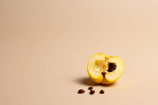 Fresh Quince Cut in Half with Seeds Isolated on Beige Background
