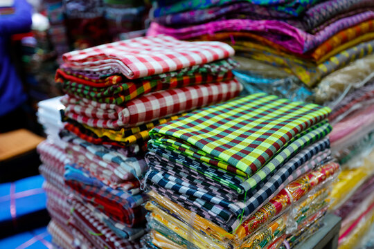 Towering piles of multicolored checkered cloths create a rainbow spectacle on Cambodian market. Siem Reap. Cambodia.